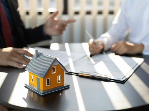 Insurance agent consulting real estate insurance detail to customer.