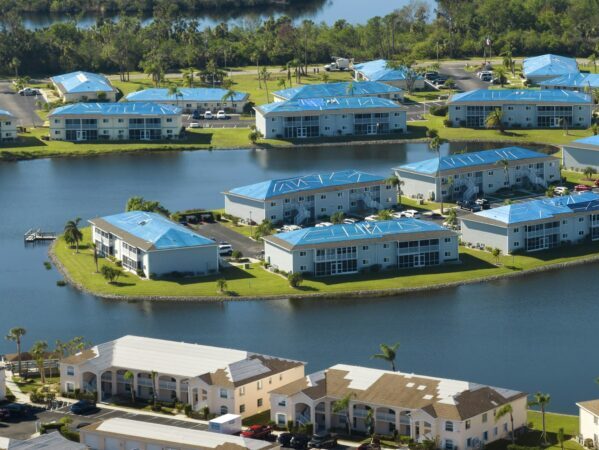 Leaking roofs of residential condos covered with protective tarp sheets against rain water